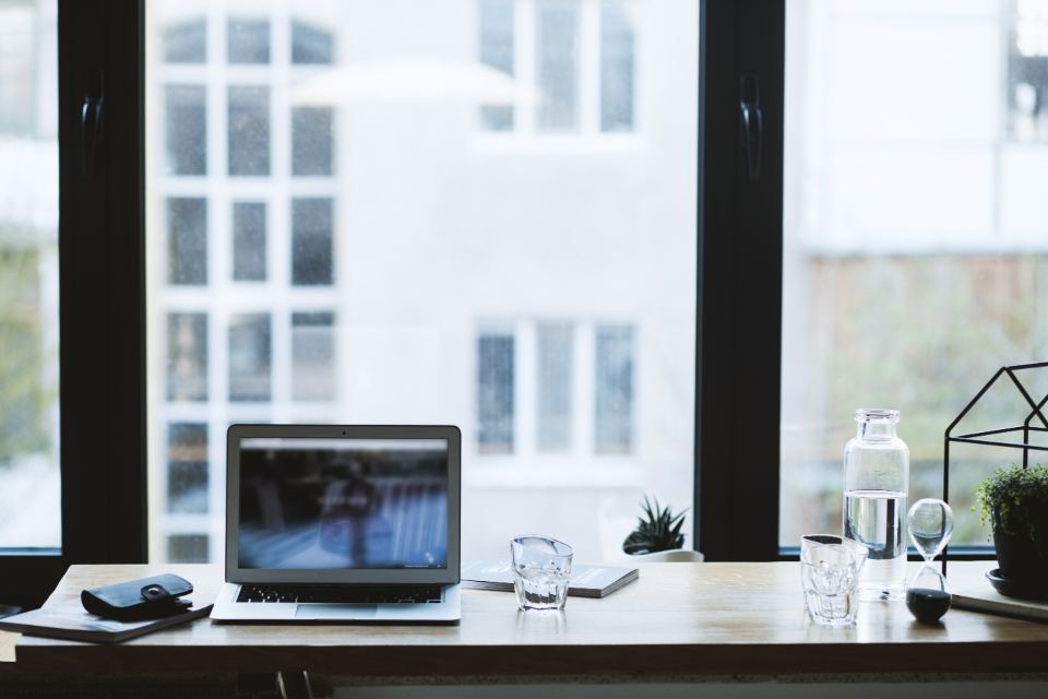 A laptop on a desk by an office window, with no server equipment in sight
